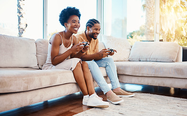 Image showing Gamer, funny and a black couple on a sofa in the living room of their home together for bonding. Love, fun or leisure with a gaming man and woman playing online using a console in their house