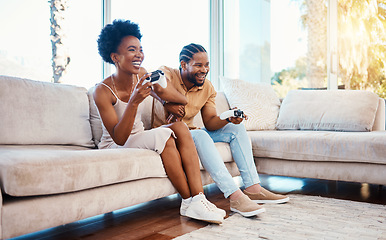 Image showing Gaming, funny and a black couple on a sofa in the living room of their home together for bonding. Love, fun or leisure with a gamer man and woman playing online using a console in their house