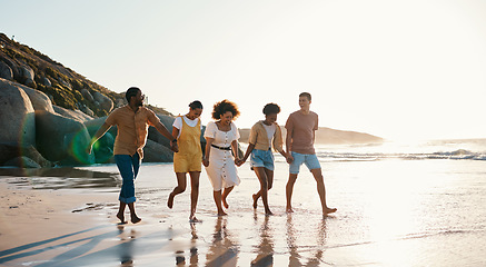 Image showing Summer, friends and people happy at sunset beach for fun, holding hands and travel with love. Diversity, men and women group in nature with sand, freedom and happiness on a vacation or holiday