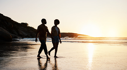 Image showing Beach, sunset and silhouette couple walking on sand, holding hands and enjoy romantic time together. Wellness, summer freedom and dark shadow of people bonding, talking and relax on tropical date