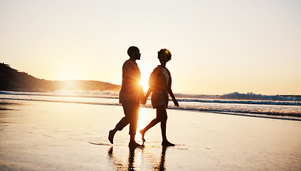 Image showing Beach sunset, silhouette and couple walking, holding hands and enjoy romantic conversation, freedom and travel holiday. Love, sea and dark shadow of people bonding, talking and relax on tropical date