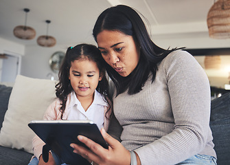 Image showing Tablet, study and a mother on the sofa with her daughter in the living room of their home together. Education, family or children with a mother and girl looking at online homework for learning