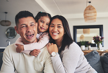 Image showing Hug, smile and portrait of girl with her parents bonding together in the living room of their home. Care, love and child holding her father and mother while relaxing in the lounge of a family house.