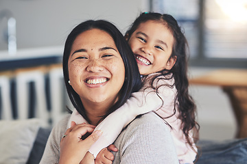 Image showing Hug, mother and daughter smile for a portrait at home with love, care and happiness. A young woman and girl child together on a lounge sofa for fun time, playing and security or relax in family house