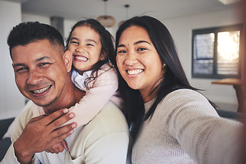 Image showing Selfie, happy and portrait of a family with a smile bonding in the living room of their home. Together, love and young happy parents taking a picture with their sweet girl child for memories in house