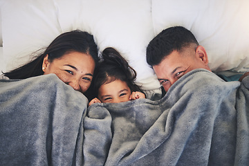 Image showing Happy, hide and relax with family in bed for morning, wake up and playful from above. Love, care and bonding with parents and child in bedroom at home for weekend, resting and happiness together