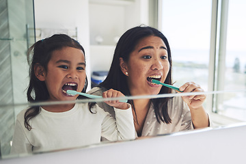 Image showing Mother, child and brushing teeth in dental hygiene, morning routine or healthcare together by mirror in bathroom. Happy mom and daughter cleaning mouth in tooth whitening, oral or gum care at home