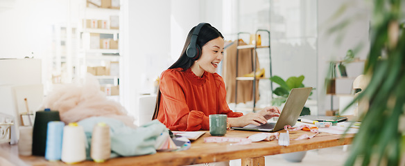 Image showing Video call, laptop and ecommerce with asian woman and headphones in warehouse for networking, fashion and design. Online shopping, meeting and conference with girl for clothes, startup and retail