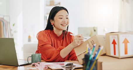 Image showing Box, ecommerce and laptop with asian woman writing for order, delivery and online shopping distribution. Seller, package and retail with small business owner for parcel, shipping and labelling