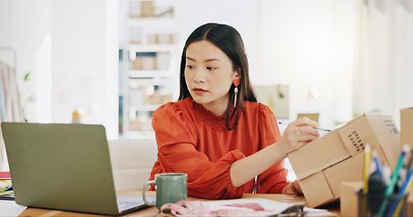 Image showing Box, ecommerce and laptop with asian woman writing for order, delivery and online shopping distribution. Seller, package and retail with small business owner for parcel, shipping and labelling