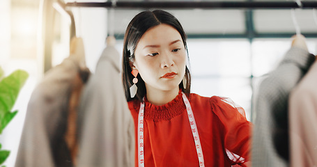 Image showing Fashion designer, woman and clothes choice on rack in shop for choosing outfit. Boutique, store and smile of happy Asian tailor or seamstress checking selection of clothing for inventory in wardrobe.