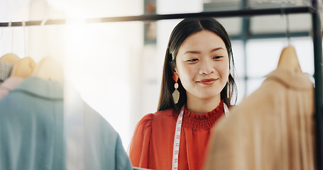 Image showing Fashion designer, woman and clothes choice on rack in shop for choosing outfit. Boutique, store and smile of happy Asian tailor or seamstress checking selection of clothing for inventory in wardrobe.