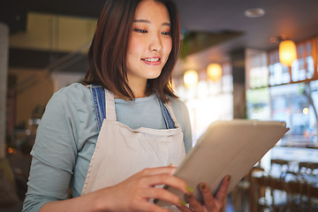 Image showing Restaurant, tablet and Asian woman online for order for food service, inventory and check menu. Coffee shop, small business and happy waitress, barista or manager on digital tech for cafe website