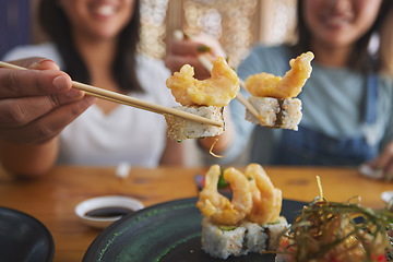 Image showing Chopsticks, woman hands and shrimp sushi closeup at a table with Japanese cuisine food at restaurant. Young women, eating and tempura prawn with fish for lunch and meal on a plate with a smile