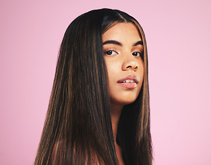 Image showing Portrait, salon and hair with a woman on a pink background in studio for shampoo treatment. Face, skincare or haircare and a confident young model with natural beauty or aesthetic keratin cosmetics