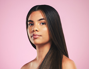 Image showing Portrait, beauty and hair with a woman on a pink background in studio for shampoo treatment. Face, skincare or haircare with a confident young model at the salon for natural or keratin cosmetics