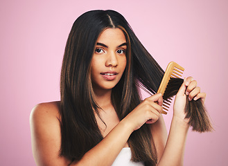 Image showing Portrait, woman and brush hair in studio for smooth texture, shine and keratin treatment on pink background. Natural beauty, face and model with comb tools for aesthetic hairstyle with growth shampoo