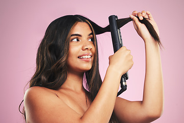 Image showing Woman, hair and care with iron in studio for beauty, cosmetic treatment and shine on pink background. Face of young model, hairstyle and heating equipment of electrical tools for aesthetic texture