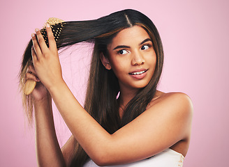 Image showing Woman, hair and care with brush in studio for healthy texture, shine and keratin on pink background. Natural beauty, face and model with comb tools for clean aesthetic hairstyle with growth shampoo