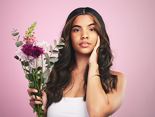 Image showing Woman, flowers and portrait in studio for skincare, cosmetics and natural aesthetic on pink background. Face, model and eco beauty with floral plants, sustainability and bouquet for vegan dermatology
