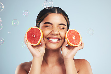 Image showing Smile, woman and grapefruit skincare in studio for natural, cosmetic or wellness on grey background. Beauty, happy and model face with citrus facial, fruit or vitamin c, collagen and bubble aesthetic