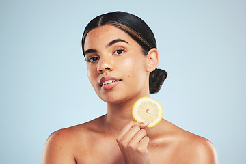 Image showing Portrait, woman and lemon in studio for skincare, wellness and organic cosmetics on grey background. Fruit, slice and face of model with citrus treatment for vitamin c, collagen and anti aging detox