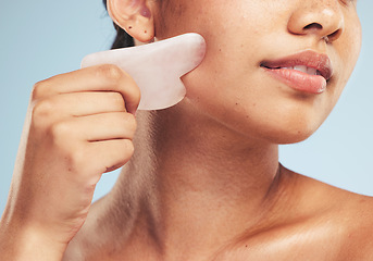 Image showing Skincare, gua sha and woman with face massage on studio for anti aging, wellness and circulation on grey background. Stone, facelift and beauty model with rose quartz for lymphatic drainage facial