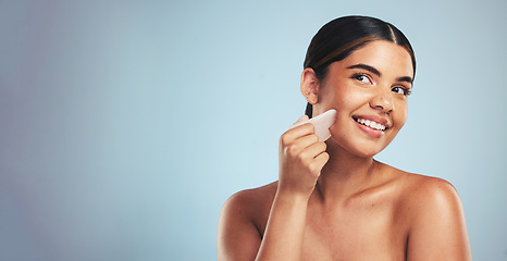 Image showing Gua sha, skincare and woman with face massage in studio for anti aging, wellness and circulation on grey background. Crystal, facelift and beauty model with rose quartz for lymphatic drainage facial