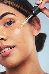 Image showing Woman, face oil and portrait in studio for beauty of aesthetic skincare, dermatology and makeup on blue background. Closeup of model with dropper for facial cosmetics, hyaluronic acid or liquid serum