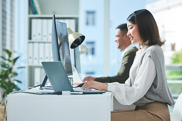 Image showing Business, planning and asian woman on laptop and computer in office for research or strategy in coworking space. Online, search and happy female designer smile for creative, networking or design