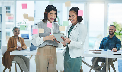 Image showing Business women, tablet and teamwork on glass board for marketing, project planning and happy ideas in meeting. Professional people for digital, sticky notes and scrum or agile presentation in office