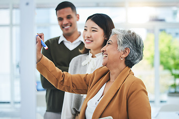 Image showing Senior woman, writing and manager at glass board with creative team and sticky notes agenda. Calendar planning, content creator schedule and management staff laughing in a business meeting teamwork