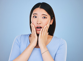 Image showing Scared, portrait and Asian woman with fear from news, announcement or horror story on blue background in studio. Shock, face and person with wow, emoji or facial expression with stress or anxiety