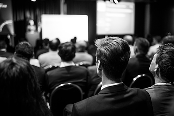 Image showing Speaker giving a talk in conference hall at business event. Rear view of unrecognizable people in audience at the conference hall. Business and entrepreneurship concept.