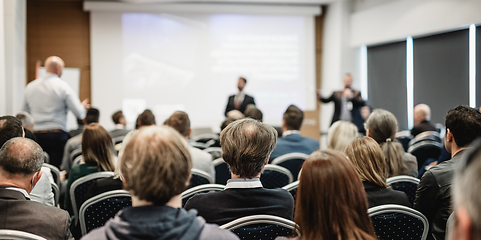 Image showing I have a question. Group of business people sitting in conference hall. Businessman raising his arm. Conference and Presentation. Business and Entrepreneurship