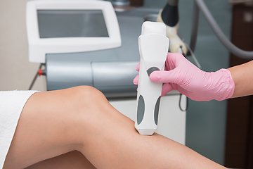 Image showing Specialist makes skin tone measurements on a womans leg