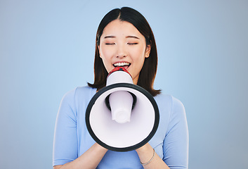 Image showing Woman, megaphone and voice for news, broadcast or student sale and announcement on blue background. Young asian person with noise for call to action, university attention or college speaker in studio