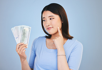 Image showing Woman, money and winner thinking of bonus offer, financial success and winning, finance loan or choice. Asian person or customer for cash, savings decision or profit ideas on blue, studio background