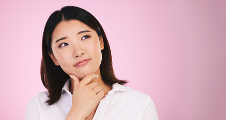 Image showing Asian woman, thinking and decision on mockup space in problem solving against a pink studio background. Female person with idea, solution or choice in memory, reminder or brainstorming on mock up