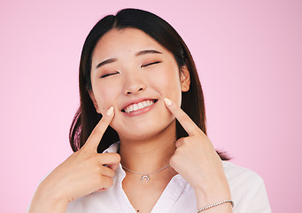 Image showing Asian woman, face and hands on smile for teeth, whitening and dental wellness or beauty on pink background in studio. Tooth, care and portrait of model with happiness for cosmetics and dentistry