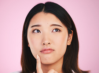 Image showing Beauty woman, thinking and confused, ideas and cosmetics decision or skincare choice on pink background. Young asian person with skin care vision, makeup inspiration or dermatology question in studio