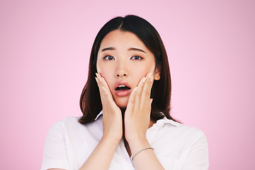 Image showing Surprise, wow and hands on woman face in studio with anxiety for fake news, drama or secret on pink background. Omg, portrait and Japanese female model shocked by gossip, announcement or emoji info