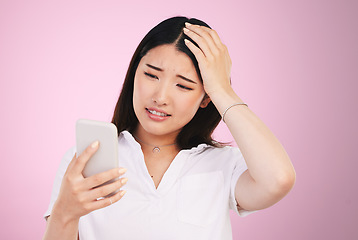 Image showing Search, phone and anxiety with face of woman in studio for networking, communication and worry. Social media, news and frustrated with asian person on pink background for technology and mobile app