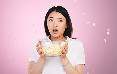 Image showing Surprise, woman and portrait with horror and popcorn, bowl or food for watching tv, movies or shock for announcement. Wow, face and scared Asian model on pink background in studio with film snack