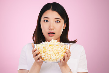 Image showing Movie, popcorn and portrait of woman with surprise, horror and bowl or food for watching tv, movies with shock. Wow, face and scared Asian model on pink background in studio with film snack