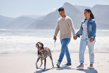 Image showing Beach, walking and couple with dog by ocean for freedom, adventure and bonding together in nature. Happy pet, excited canine and man and woman holding hands by sea for exercise, wellness and health