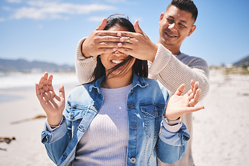 Image showing Surprise, cover eyes and couple on beach with news, love and romantic date, travel and summer outdoor. Man, woman and marriage, secret announcement and bonding, adventure and vacation in Mexico