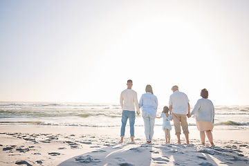 Image showing Summer, space and holding hands with big family on beach for vacation, bonding and love. Freedom, care and relax with group of people walking at seaside holiday for generations, happiness and mockup