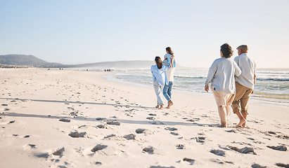 Image showing Summer, travel and back of big family on beach for vacation, bonding and love. Freedom, care and relax with group of people walking at seaside holiday for generations, happiness and mockup space