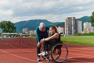 Image showing A woman with disability in a wheelchair talking with friend after training on the marathon course